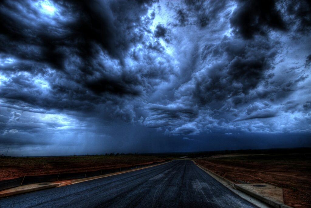 A dramatic stormy sky with dark clouds over an empty road. Nature's power captured at its peak.